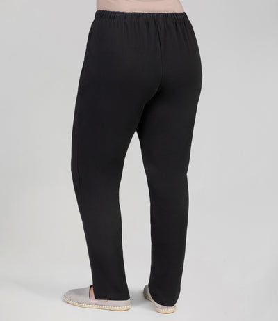 Back view, bottom half of plus sized woman, wearing JunoActives Ultraknit Loose Fit Leggings, full length, in black.