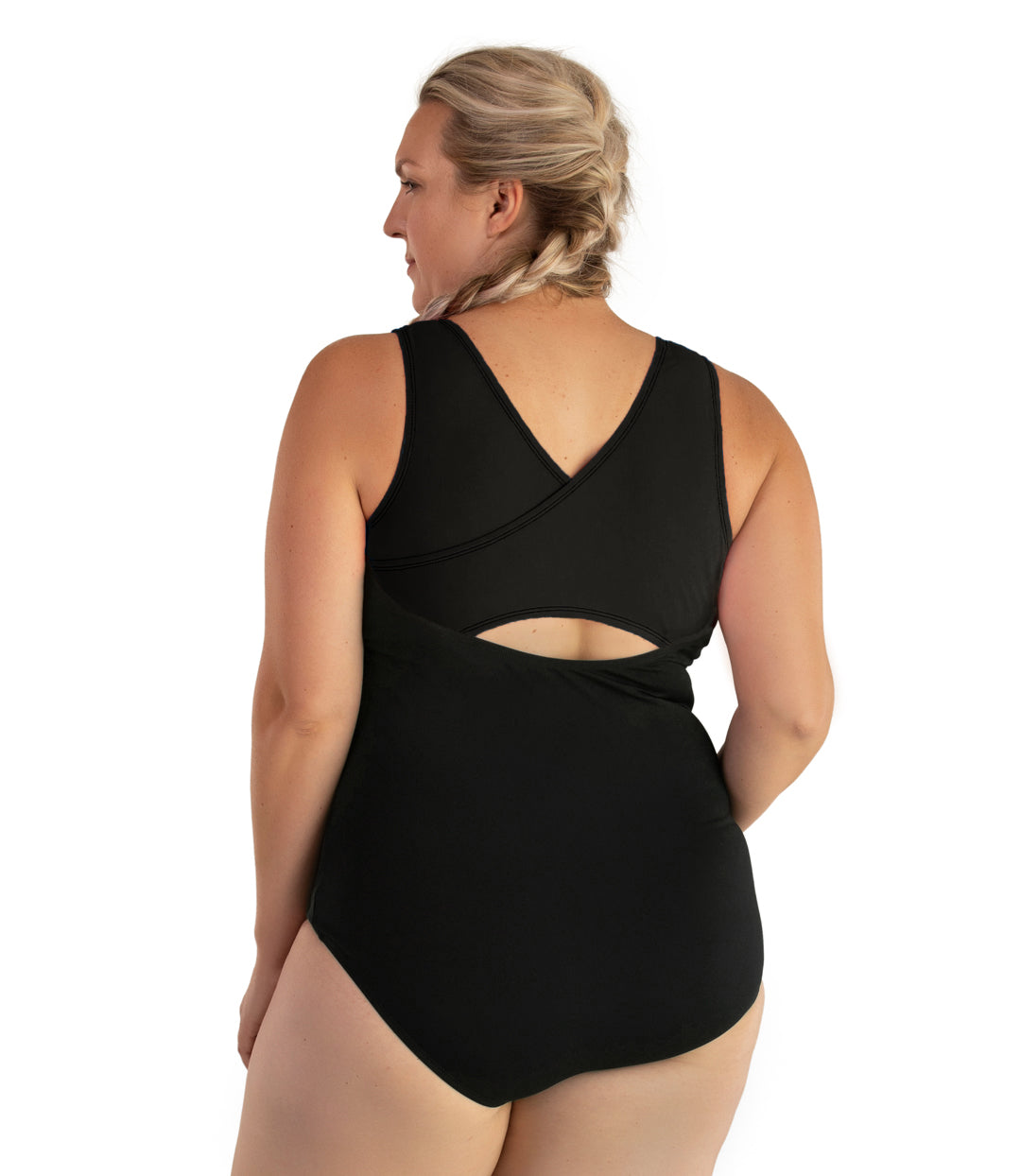 Plus size woman, back view, wearing JunoActive plus size AquaSport Crossback Tanksuit Black. The overlapping crossback detail of the tanksuit is black. The main body of the suit is solid black, keyhole opening at the mid-back.