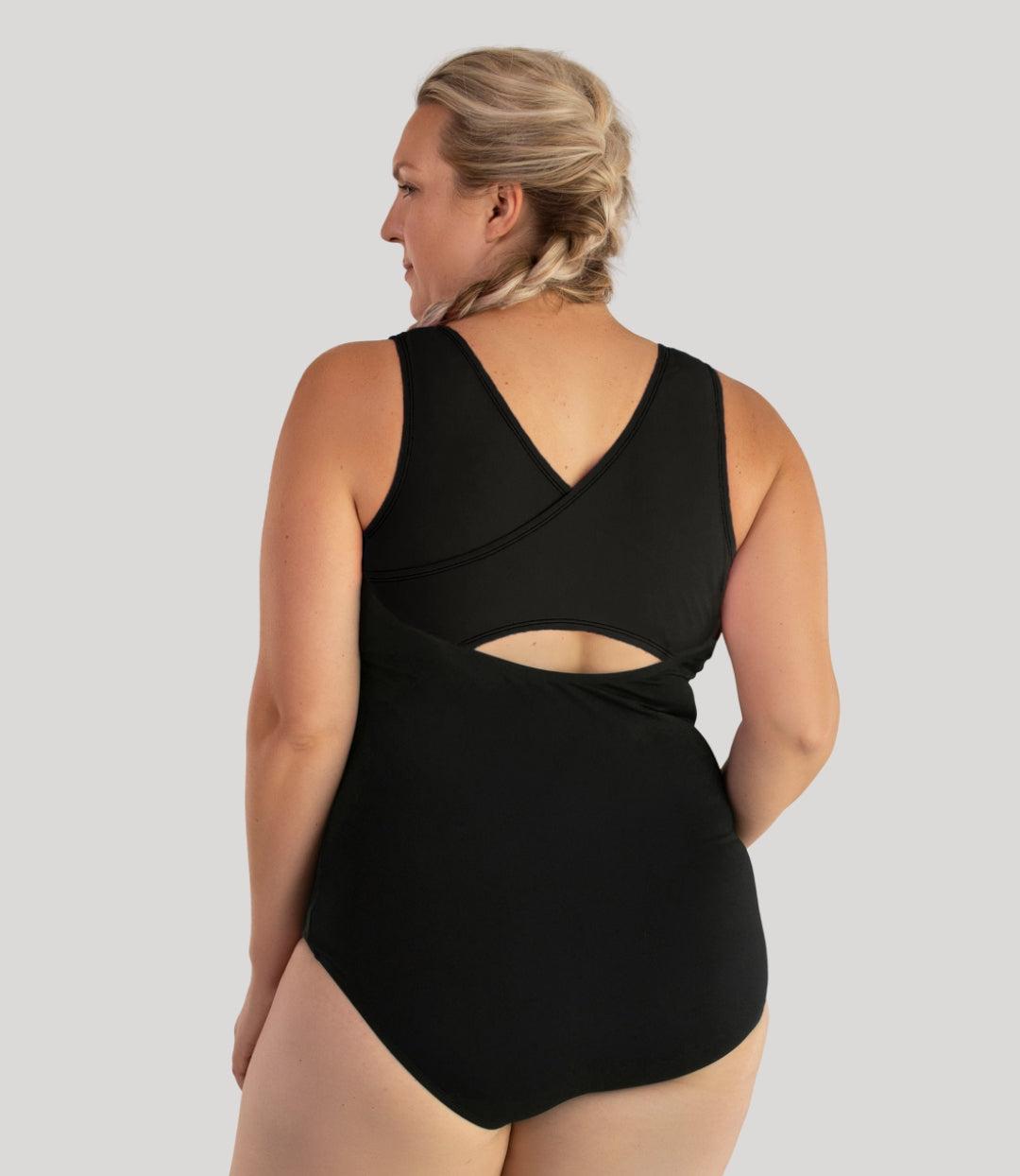 Plus size model, facing back, wearing JunoActive's Aquasport Crossback plus size Tanksuit in color black.