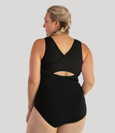 Plus size model, facing back, wearing JunoActive's Aquasport Crossback plus size Tanksuit in color black.