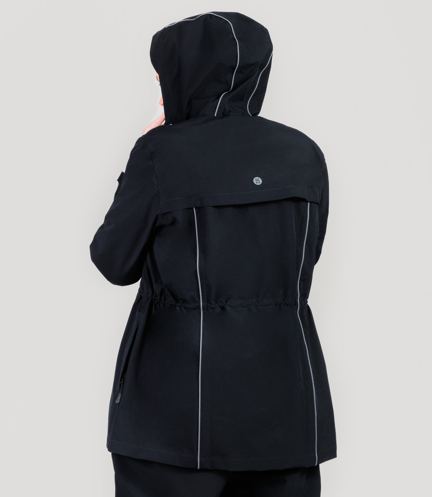 Plus size model, wearing JunoActive's Adventure Wind and Rain Jacket in color black. She is facing back with her hood up.