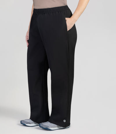 Bottom half of plus sized woman, facing front, wearing JunoActive Adventure Wind Rain Pant. These pants are full length and have pockets on each side in black.