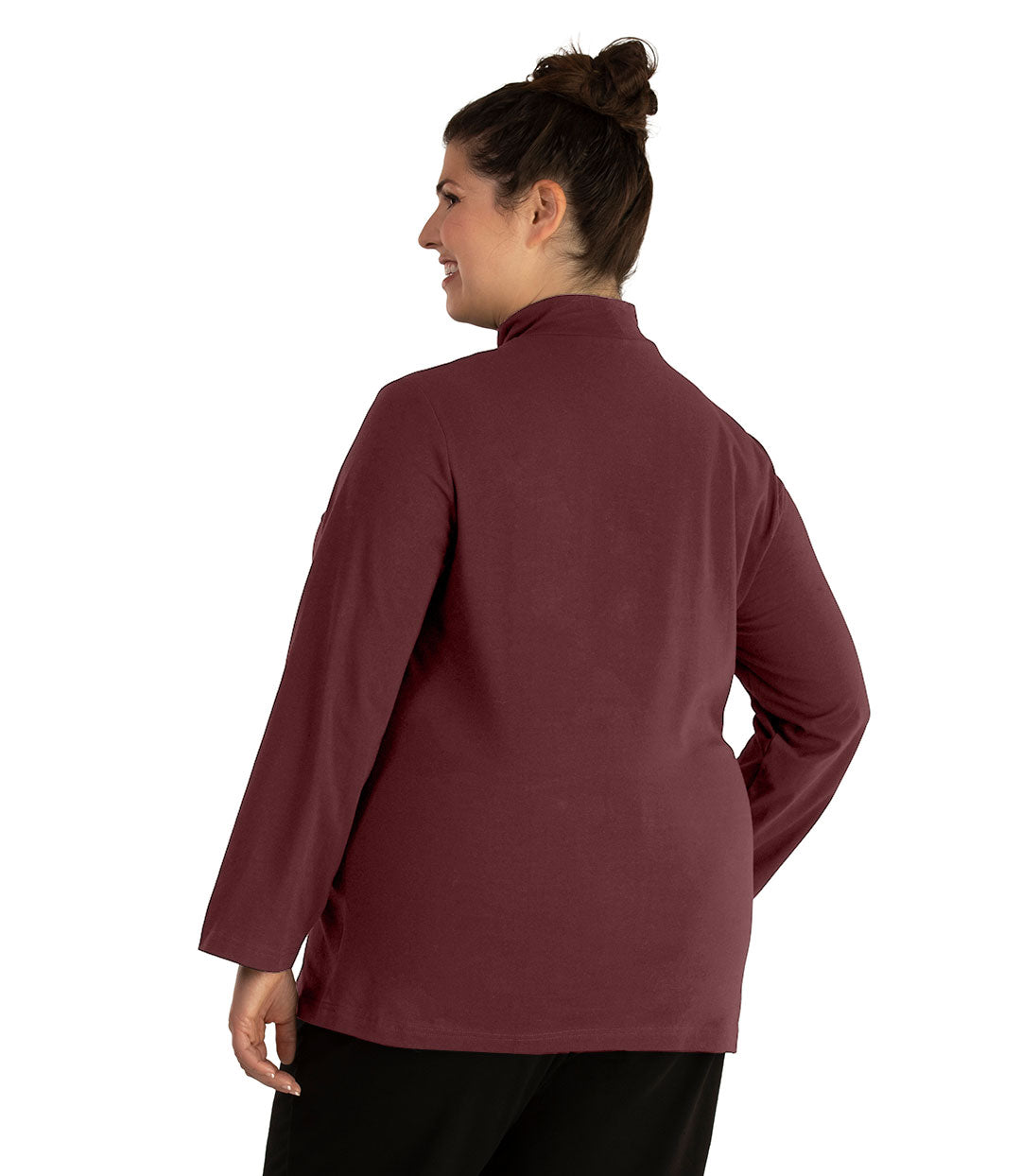 Plus size woman, facing back looking left, wearing JunoActive plus size Stretch Naturals Lite Mock Neck Top in the color Chestnut. She is wearing JunoActive Plus Size Leggings in the color Black.