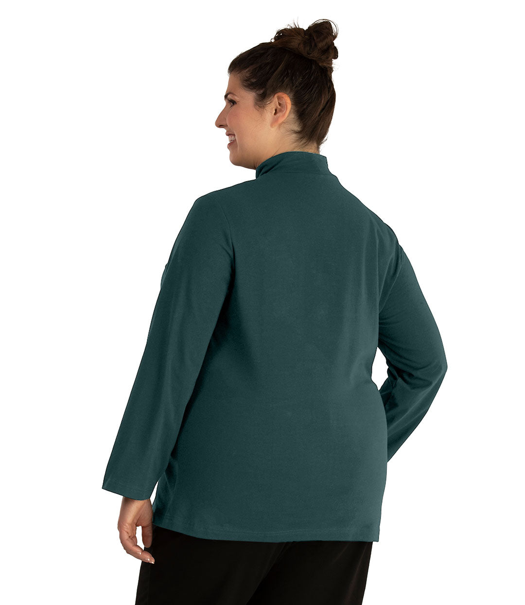 Plus size woman, facing back looking left, wearing JunoActive plus size Stretch Naturals Lite Mock Neck Top in the color Spruce. She is wearing JunoActive Plus Size Leggings in the color Black.