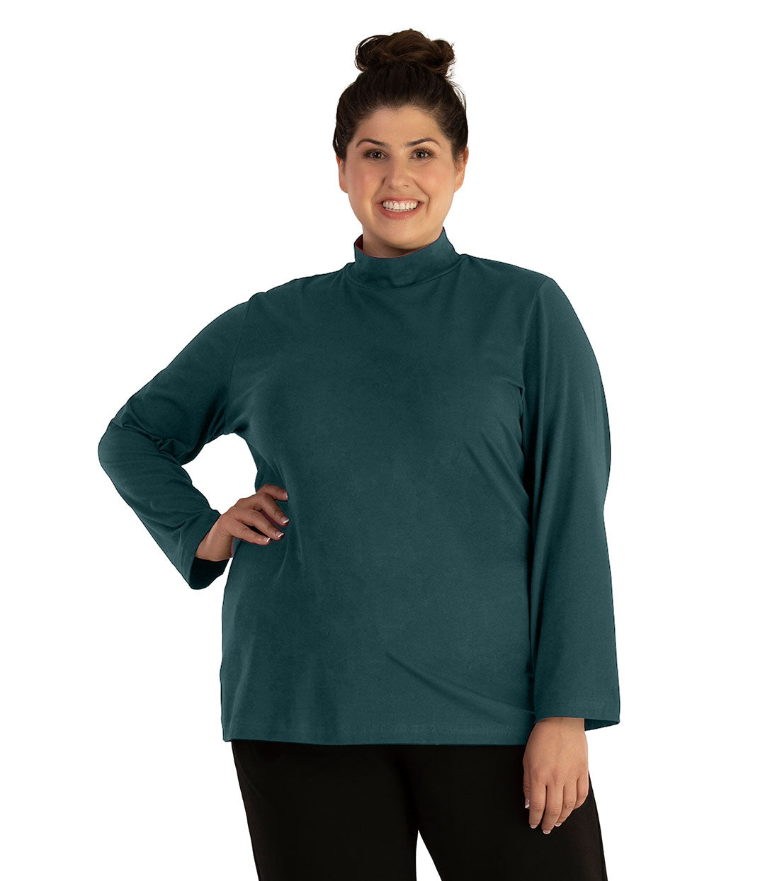 Plus size woman, facing front looking left, wearing JunoActive plus size Stretch Naturals Lite Mock Neck Top in the color Spruce. She is wearing JunoActive Plus Size Leggings in the color Black.