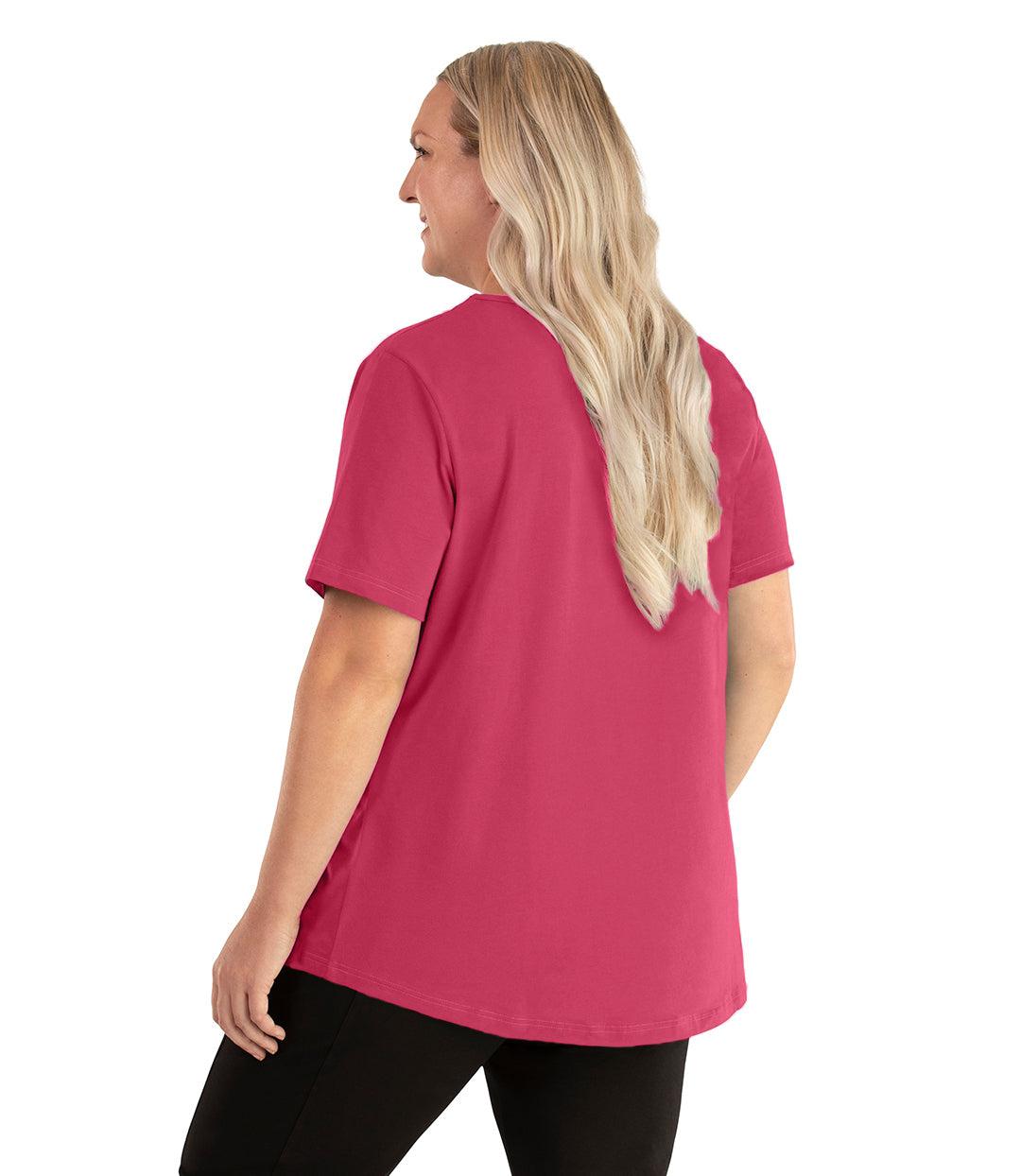  Plus size woman, facing back left, wearing JunoActive plus size Stretch Naturals Lite Short Sleeve Scoop Neck Top in the color carnation pink. She is wearing JunoActive Plus Size Leggings in the color black.