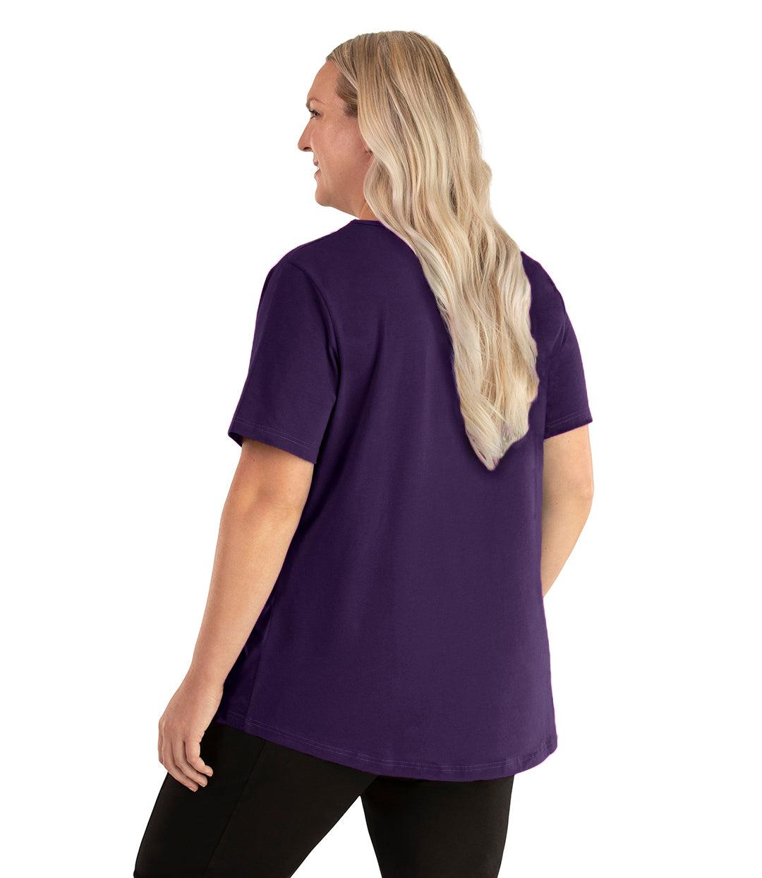  Plus size woman, facing back left, wearing JunoActive plus size Stretch Naturals Lite Short Sleeve Scoop Neck Top in the color deep plum. She is wearing JunoActive Plus Size Leggings in the color black.