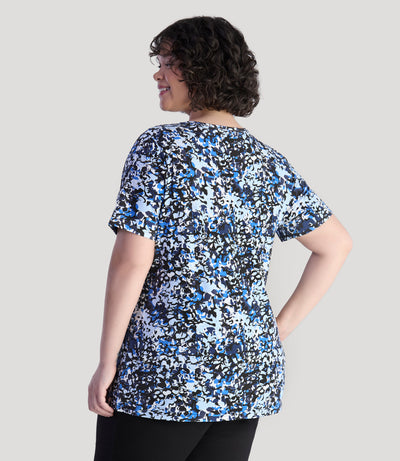 Model, facing back, wearing Junonia Lifestyle Printed Short Sleeve V-Neck top in blue melange print.