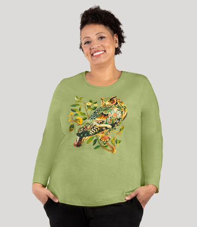 Plus size woman, facing front, wearing JunoActive's Designer Graphic Long Sleeve Scoop Neck Plus Size Top with a graphic of an owl on a branch in aloe green. 