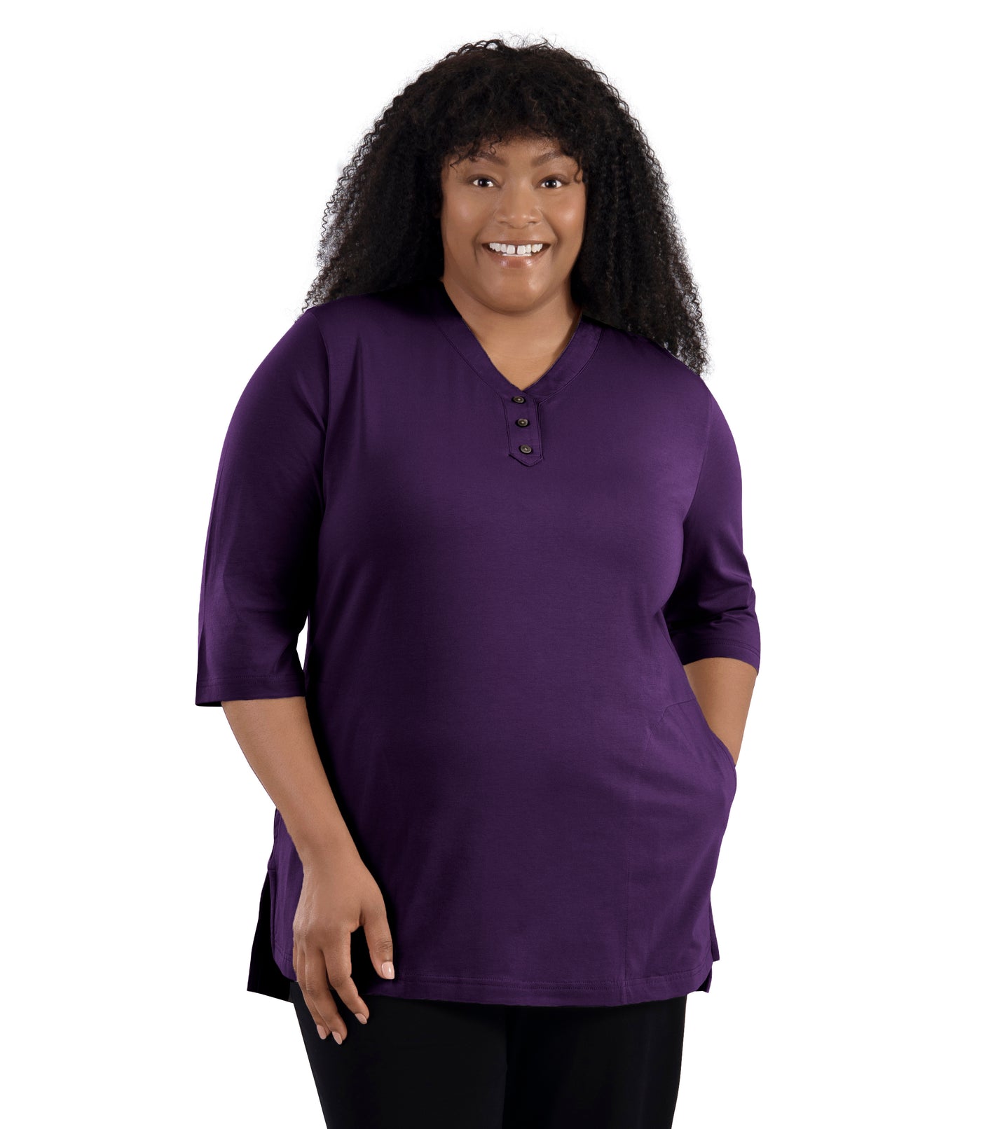 JunoActive Model wearing Stretch Naturals Lite 3/4 Sleeve Button Henley, facing front, one hand in pocket of shirt and other by her side. Color deep plum. 