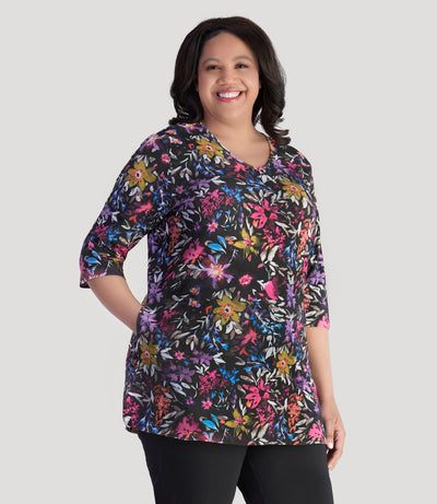 Model, facing front, wearing JunoActive's Junonia Lifestyle Printed three quarter sleeve pocketed top in floral forest print.