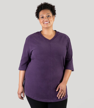 Plus size model, facing front, wearing JunoActive's Legacy Cotton Casual plus size tunic in color deep berry.