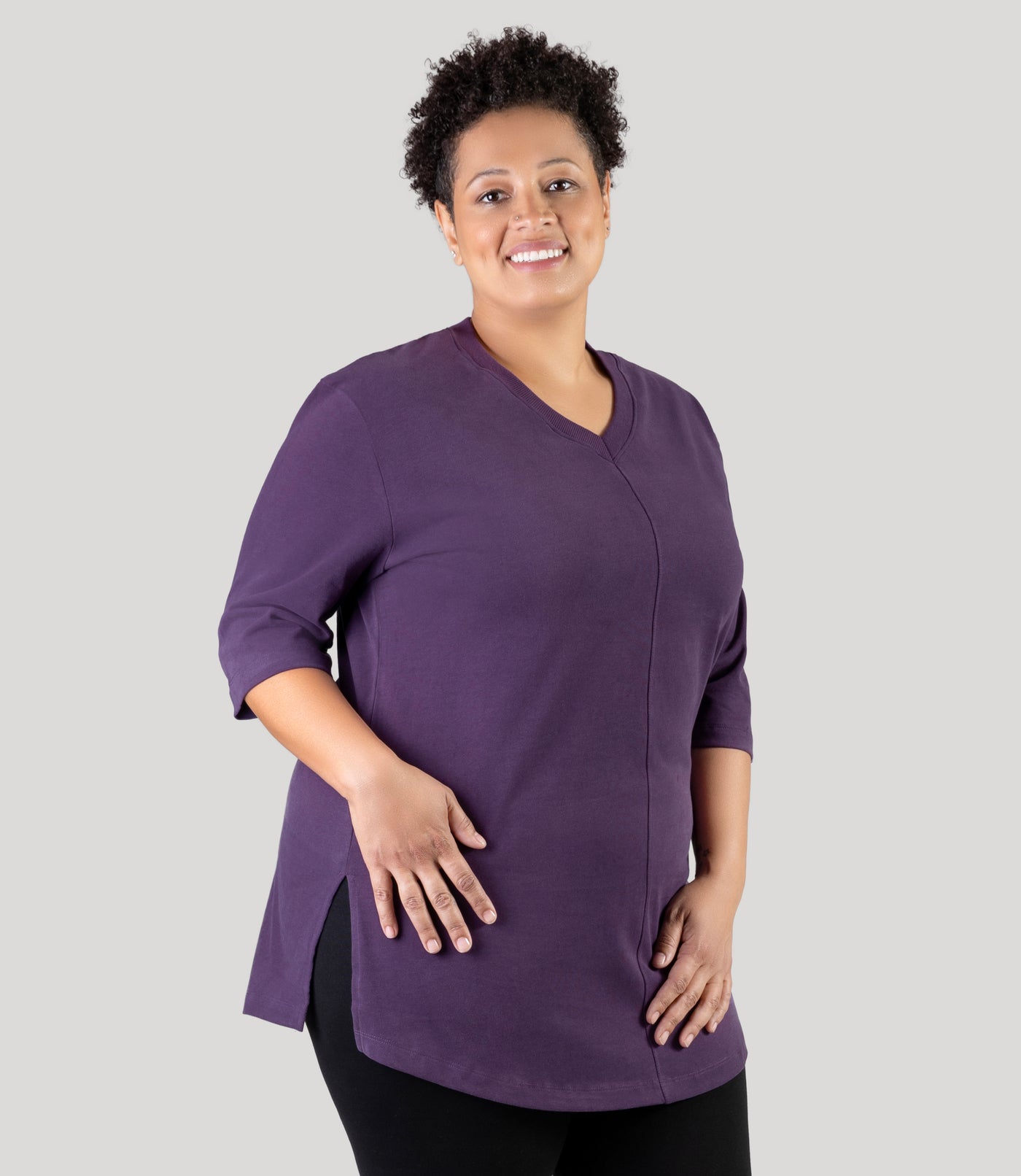 Plus size model, facing front with side slit showing, wearing JunoActive's Legacy Cotton Casual plus size tunic top in color deep berry.