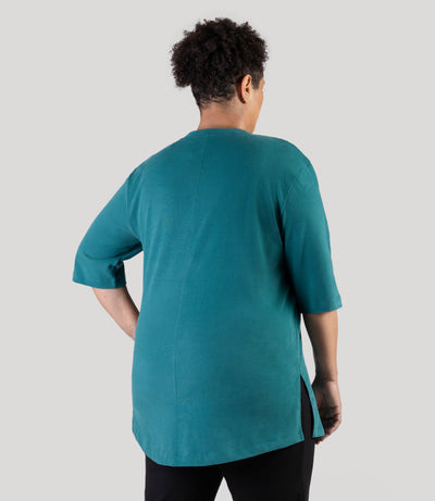 Plus size model, facing back, wearing JunoActive's Legacy Cotton Casual plus size tunic top in jasper teal color.