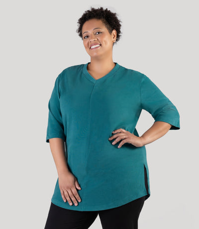 Plus size model, facing front side, showing slit, wearing JunoActive's Legacy Cotton Casual plus size tunic in jasper teal color.