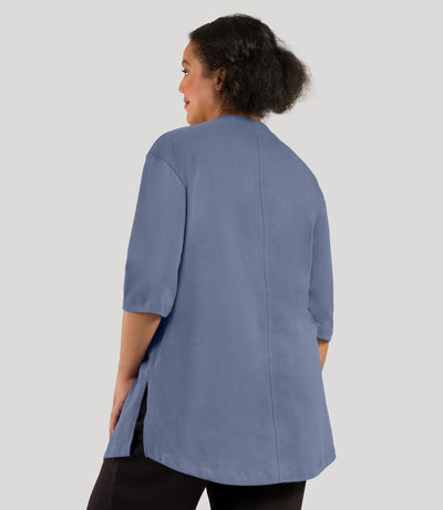 Plus size model, facing back, wearing JunoActive's Legacy Cotton Casual plus size tunic top in color blue steel.