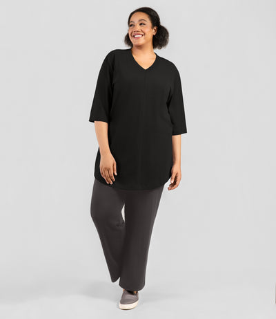 Plus size woman, facing front and full length shot, wearing JunoActive's Legacy Cotton Plus Size Casual Tunic in color black.