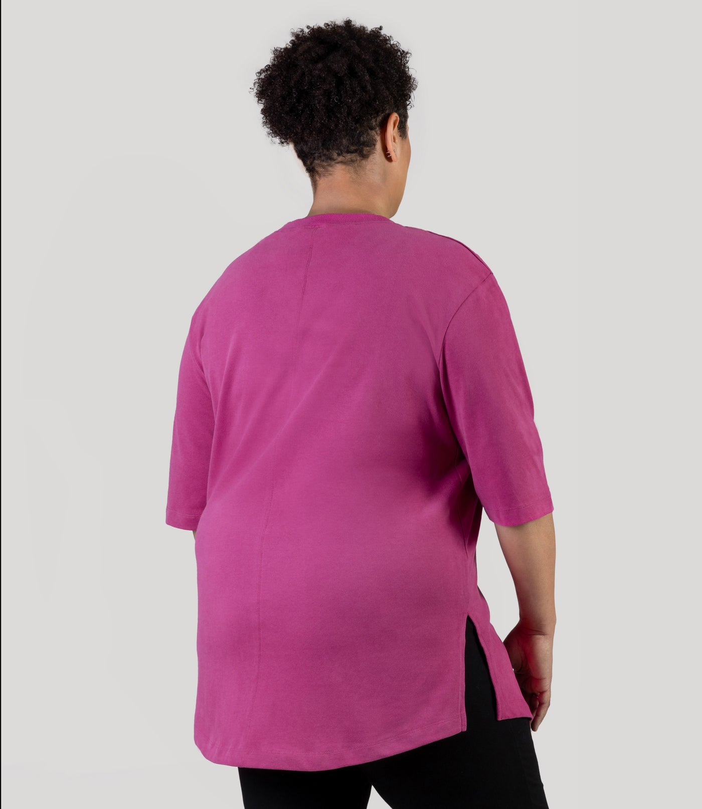 Plus size model, facing back wearing JunoActive's Legacy Cotton Casual plus size tunic top in color magenta rose.