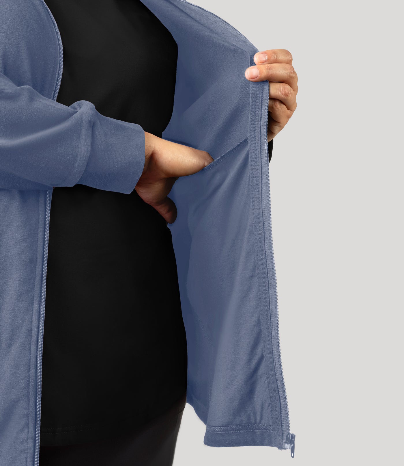 Plus size woman, close up shot of inside pocket of jacket, wearing JunoActive's Legacy Cotton Casual Mock Neck Zip up plus size jacket in color blue steel. Jacket is unzipped.