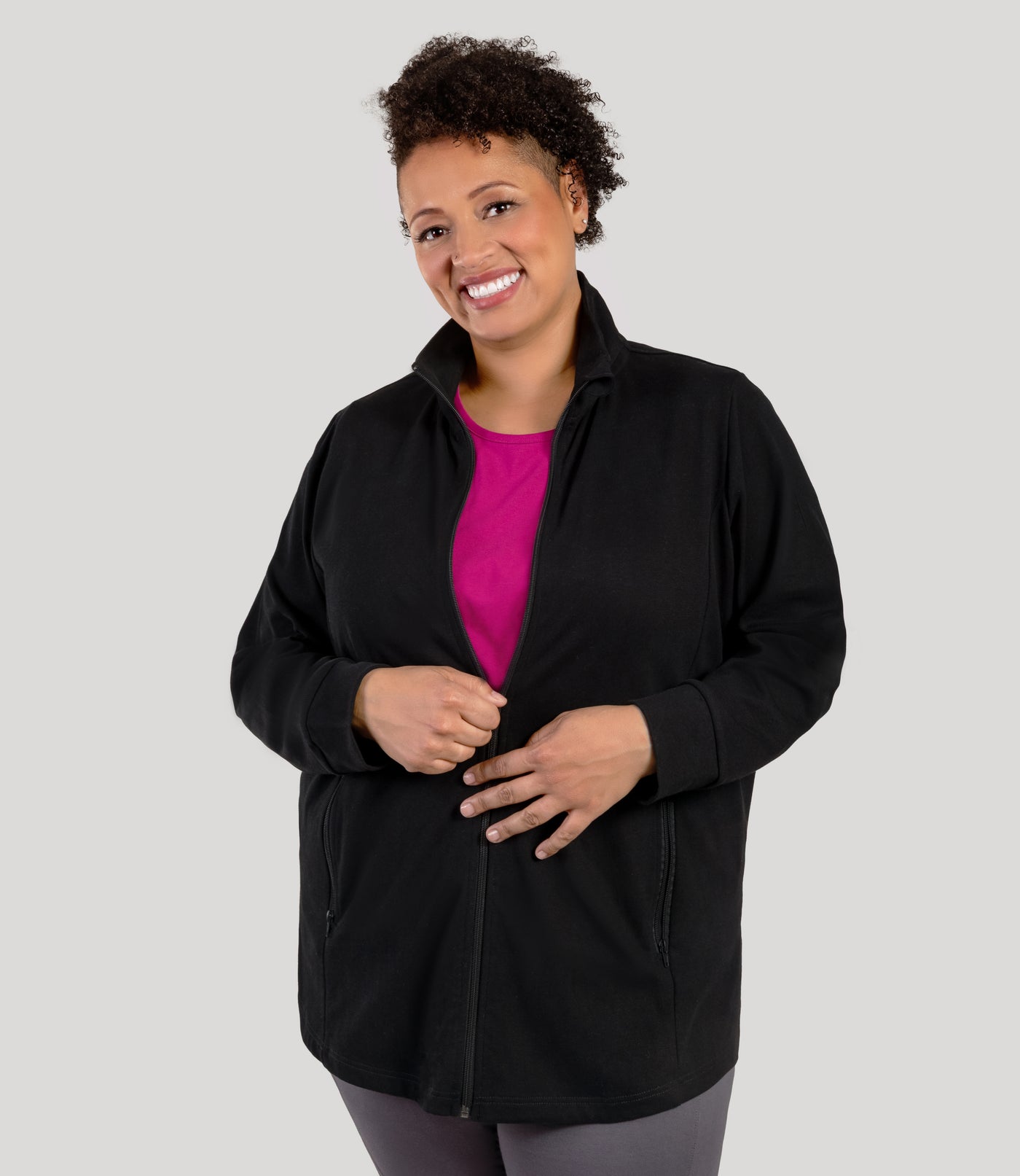 Plus size woman, facing front, wearing JunoActive's Legacy Cotton Casual Mock Neck Zip up jacket in color black. Plus size jacket is half zipped.