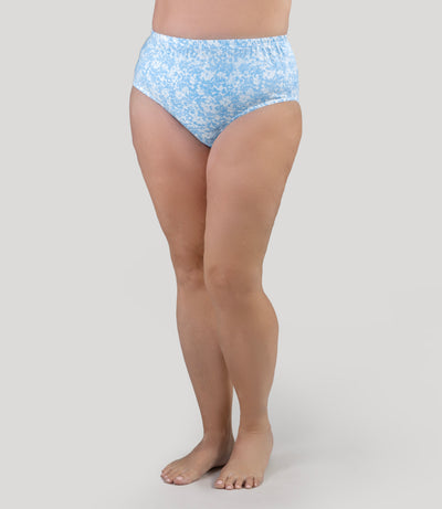 Lower half of plus size model, facing front, wearing JunoActive's Classic Brief in color blue blossoms print.