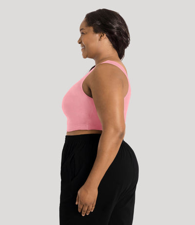 Plus size model, facing side, wearing stretch naturals full fit scoop neck bra in color peach fizz.