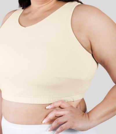 Close up of plus size model, facing front, wearing stretch naturals full fit V-neck plus size bra in color sandy.