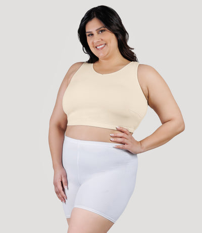 Plus size model, facing front, wearing stretch naturals full fit V-neck plus size bra in color sandy.