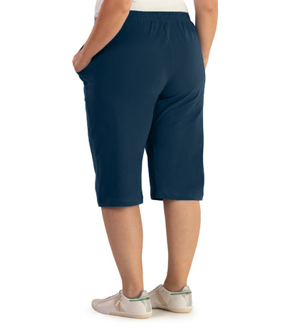 JunoActive Model, facing back, wearing Stretch Naturals Bermuda Shorts Classic Colors-Bottoms in color Indigo.