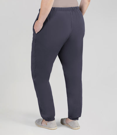 Bottom half of plus sized woman, back view, wearing junoactives stretch naturals jogger pockets oak gray. The pants are full length and have pockets on each side.