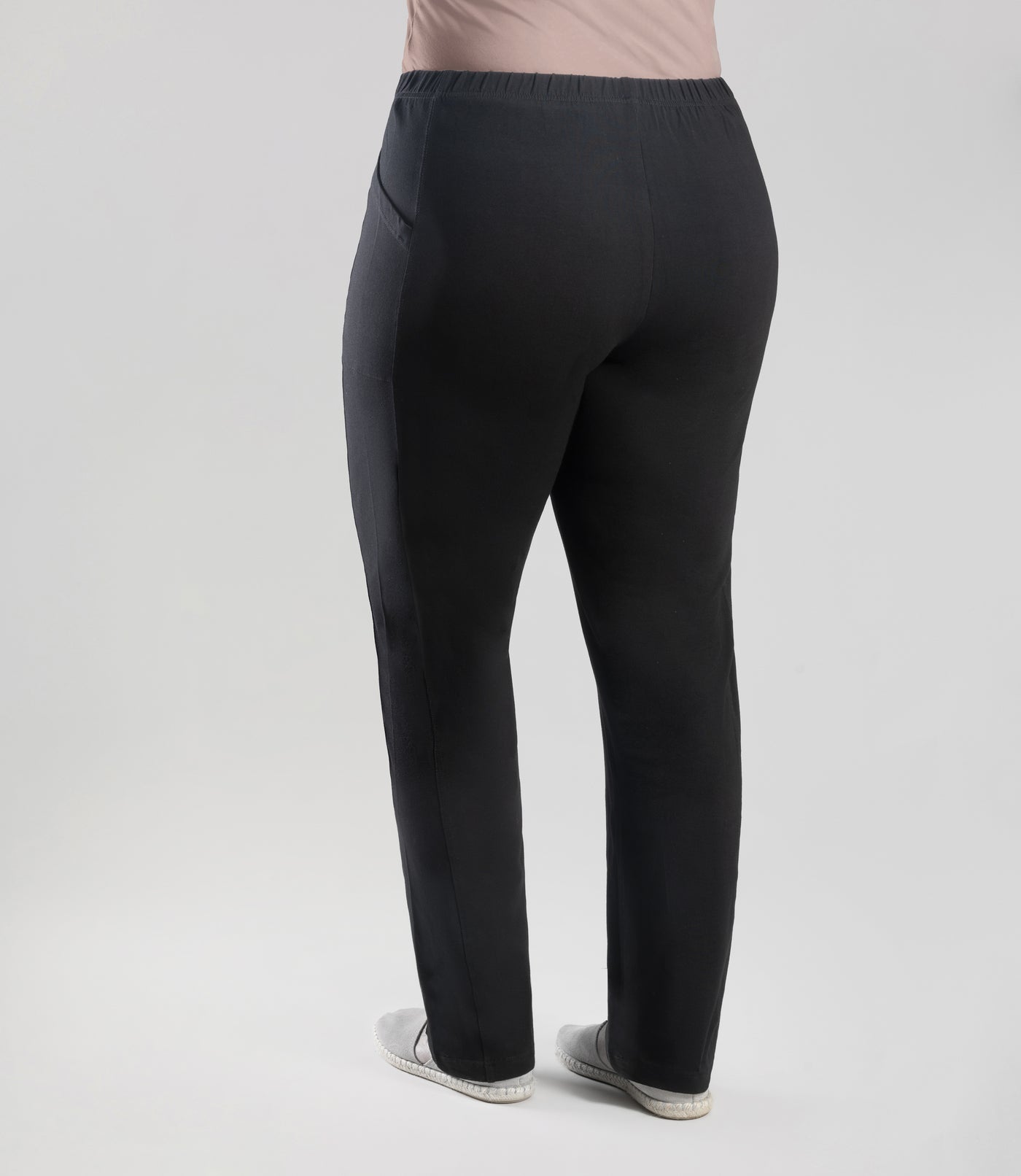 Bottom half of plus sized woman, back view, wearing JunoActive Stretch Naturals Side Pocket Loose Fit Leggings in color black. Bottom hem is at the ankle