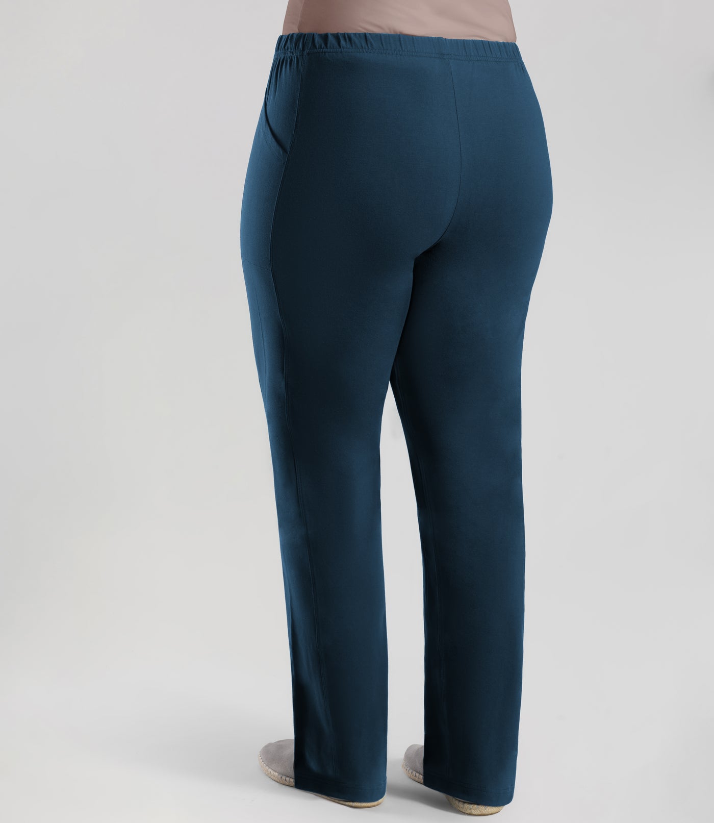 Back view, bottom half of plus sized woman, wearing JunoActive Stretch Naturals Side Pocket Loose Fit Leggings in color indigo. Bottom hem is at the ankle