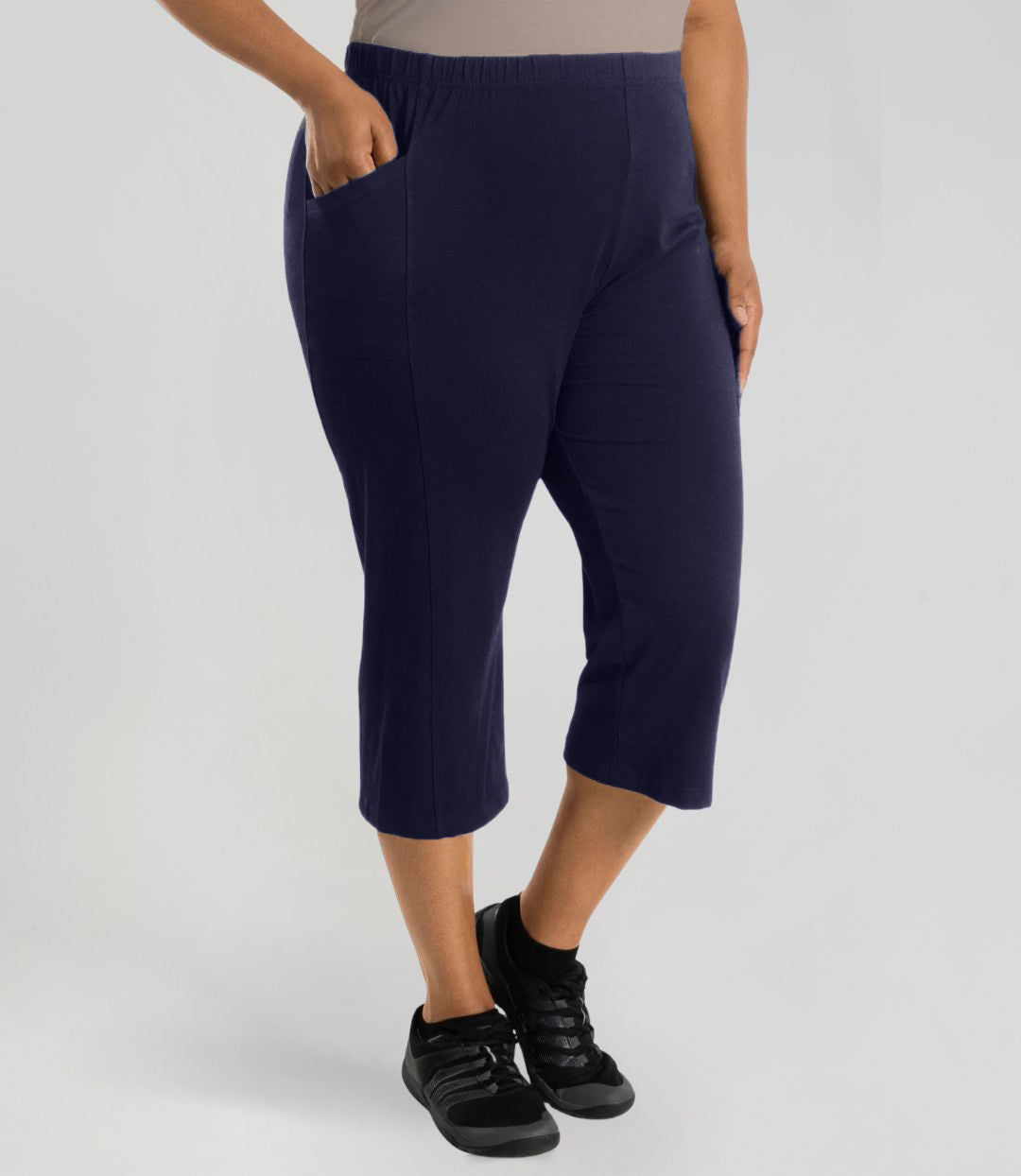 Plus size model, facing front, wearing Stretch Naturals Side Pocket Capri Classic Colors in color dark navy.