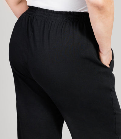 Plus size model, facing back close up, lower half of body from waist down, wearing JunoActive's Stretch Naturals Full Fit Pear plus size Pant in color black.