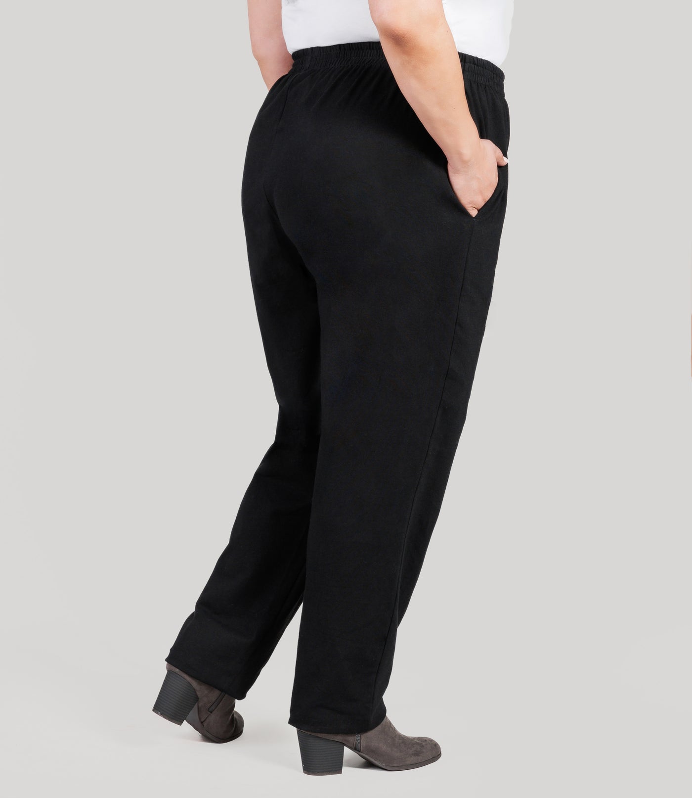 Plus size model, facing back, lower half of body from waist down, wearing JunoActive's Stretch Naturals Full Fit Pear plus size Pant in color black.