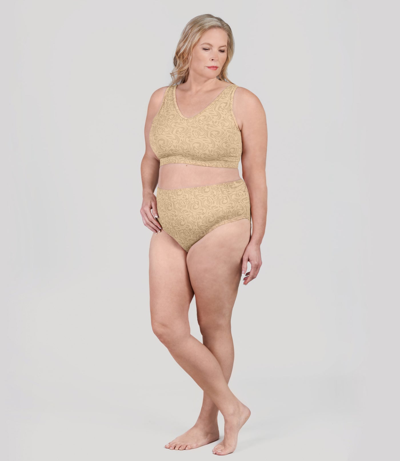 Plus size woman, facing front, wearing JunoActive's Junowear Hush V-neck plus size Bra in ecru swirl print.