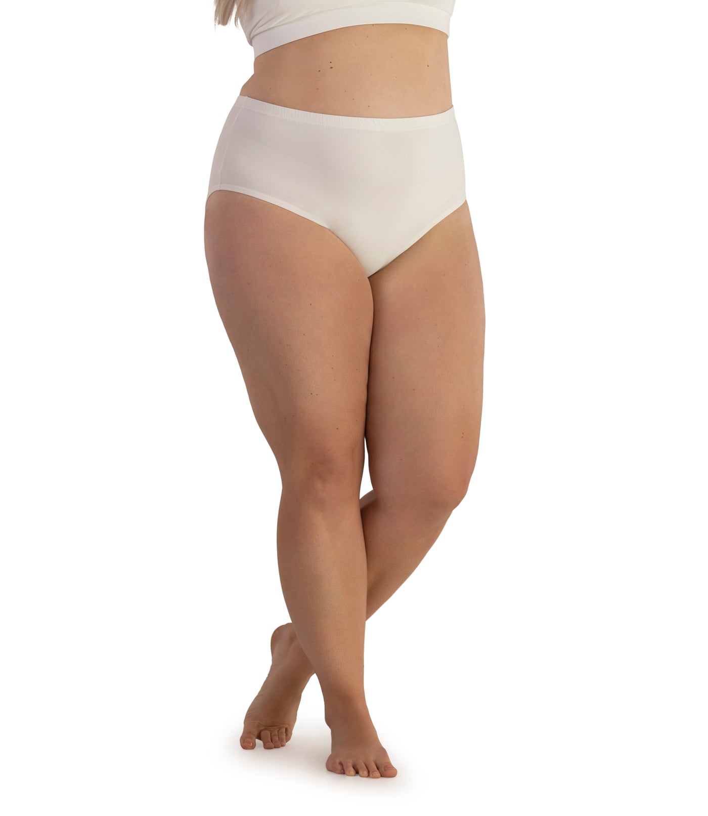 Bottom half of plus sized woman, facing front, wearing JunoActive Junowear Hush Briefs in white. This brief fits to the waistline with conservative leg opening.