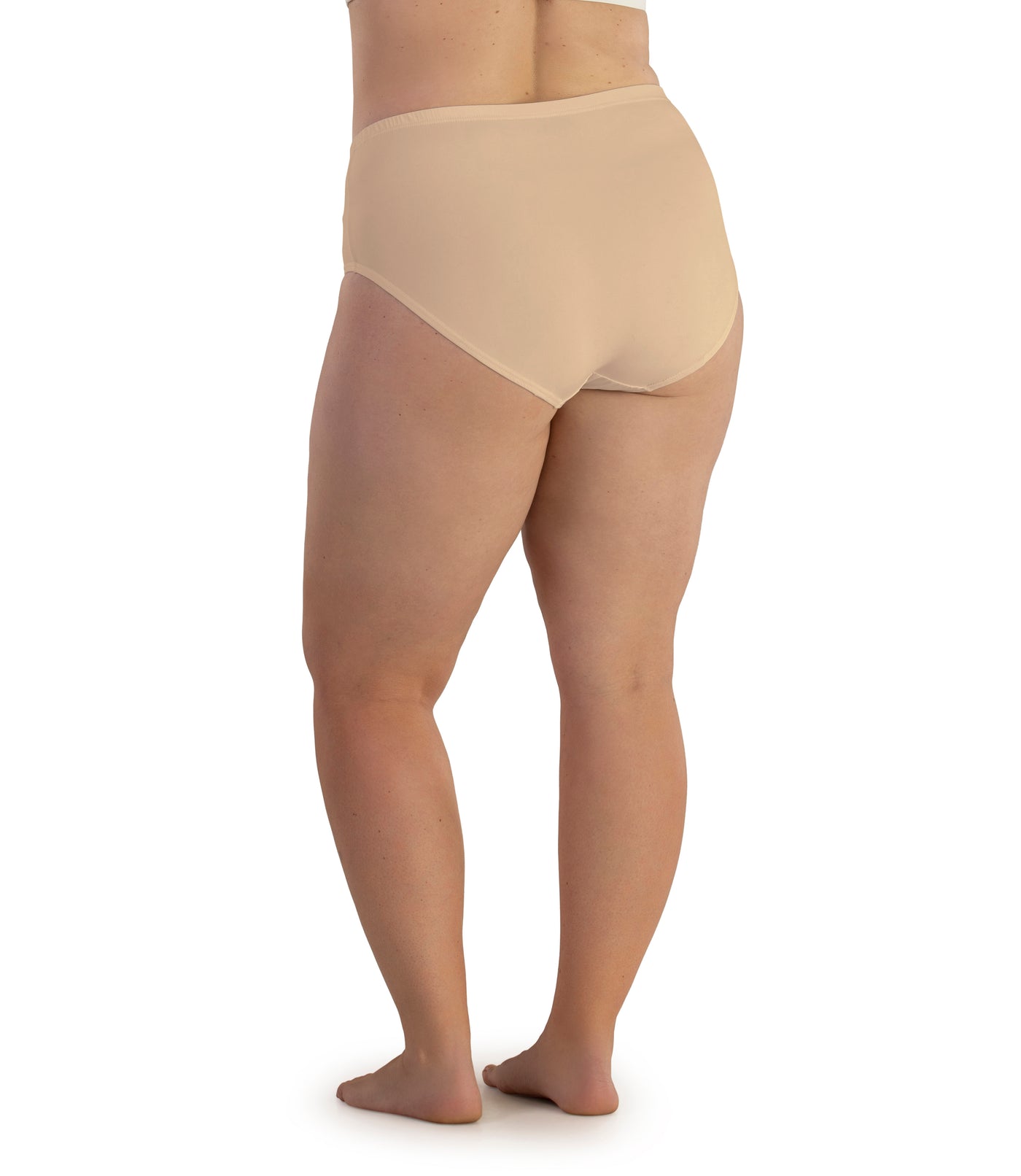 Bottom half of plus sized woman, back view, wearing JunoActive Junowear Hush Briefs in ecru. This brief fits to the waistline with conservative leg opening.