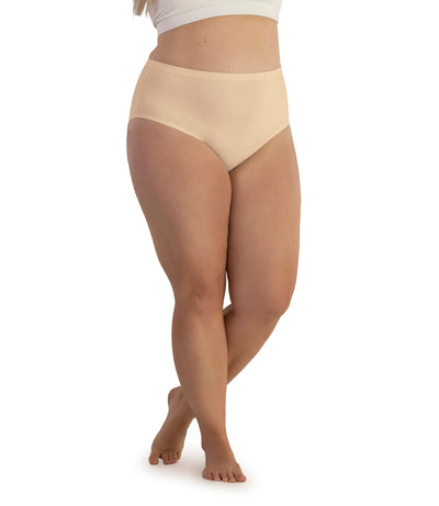 Bottom half of plus sized woman, facing front, wearing JunoActive Junowear Hush Briefs in ecru. This brief fits to the waistline with conservative leg opening.