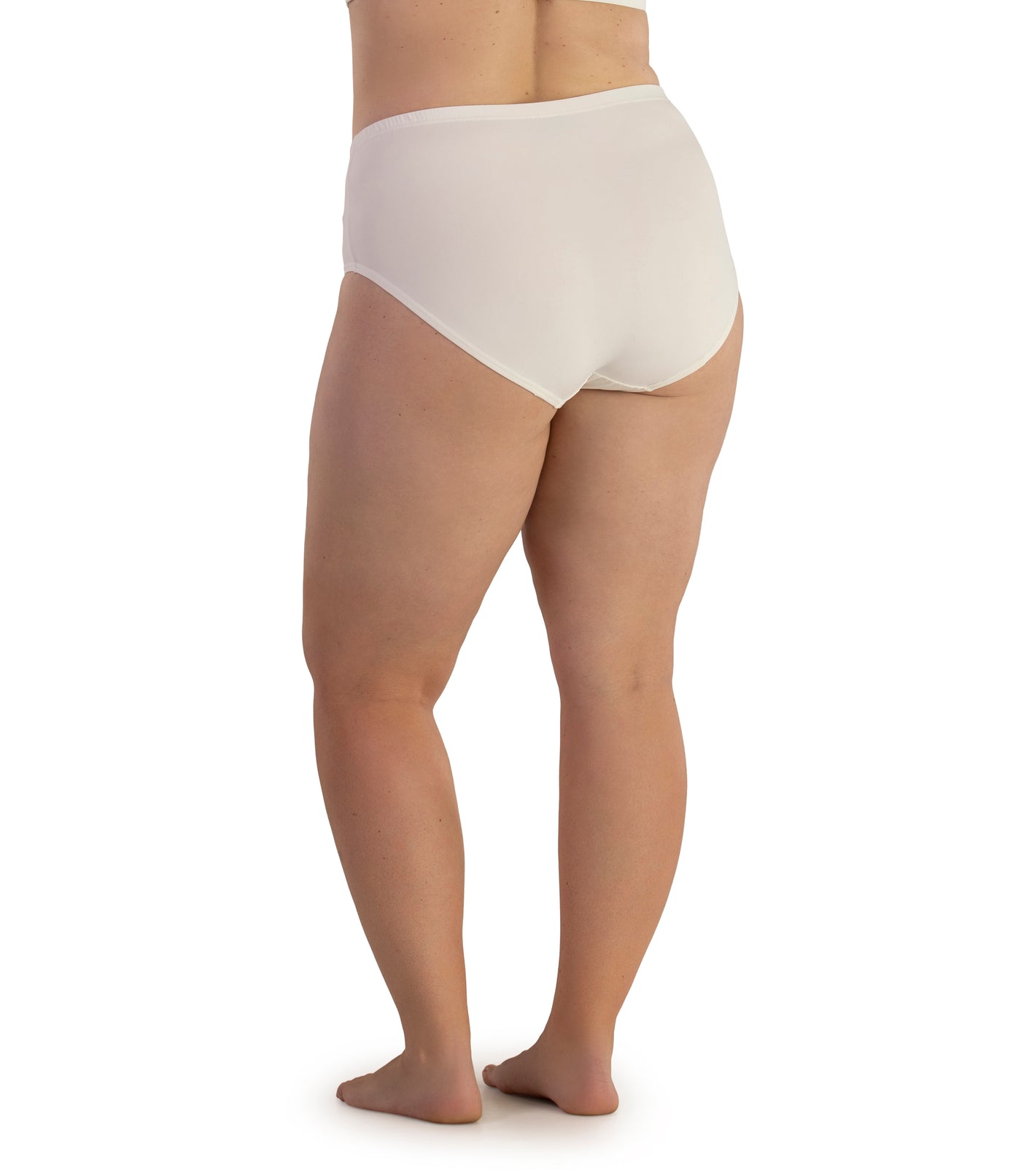 Bottom half of plus sized woman, facing back, wearing JunoActive Junowear Hush Briefs in white. This brief fits to the waistline with conservative leg opening.