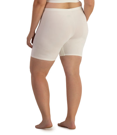 Bottom half of plus sized woman, facing back, wearing JunoActive Junowear Hush Boxer Brief in color white. This fitted boxer fits to the waistline and leg opening is a few inches above the knee.