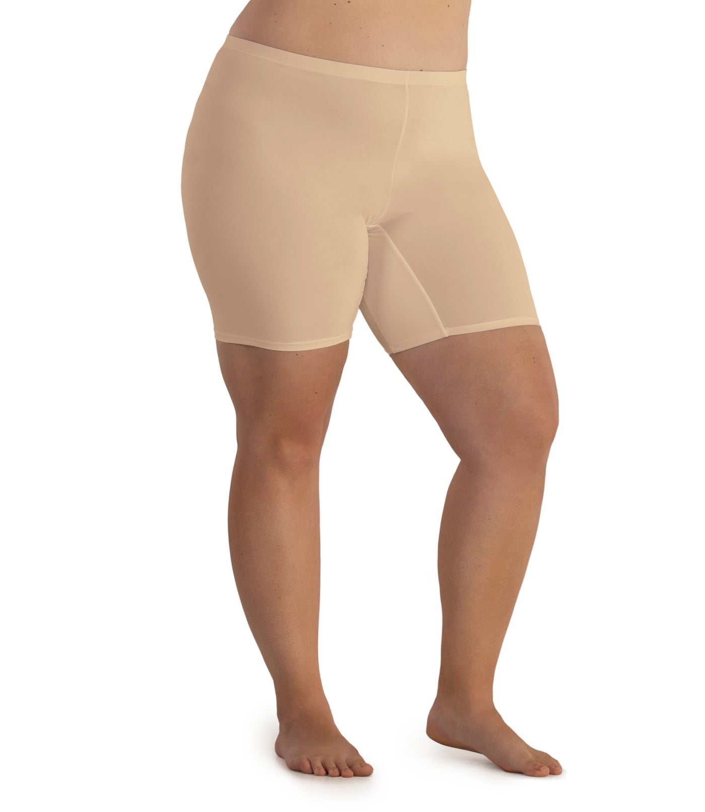 Bottom half of plus sized woman, facing side front, wearing JunoActive Junowear Hush Boxer Brief in color ecru. This fitted boxer fits to the waistline and leg opening is a few inches above the knee.