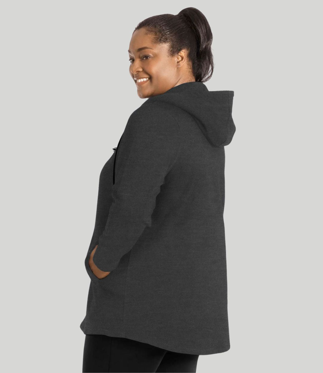 Model facing back, wearing JunoActive's MaVie Zip Front Hoodie in deep heather grey. Hands in pockets of hoodie.