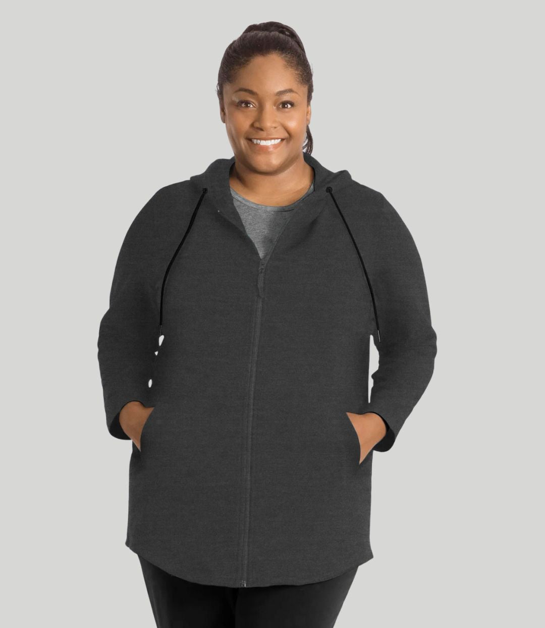 Model facing front, wearing JunoActive's MaVie Zip Front Hoodie in deep heather grey. Hands in pockets of hoodie.