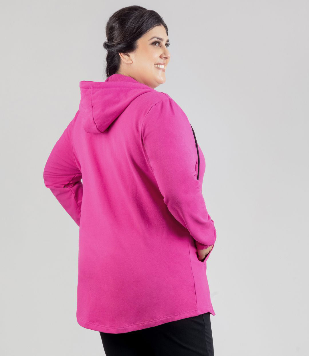 Model facing back, wearing JunoActive's MaVie Zip Front Hoodie in Magenta Pink. Hands in jacket pockets.