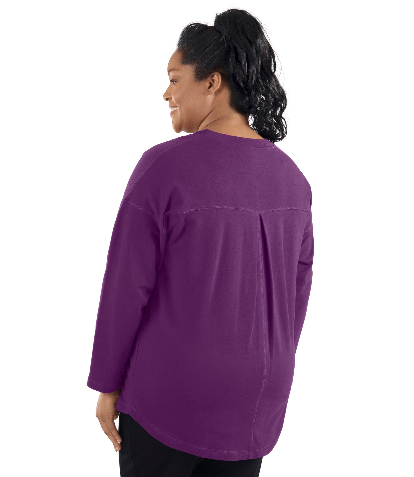 Plus-size model, facing back, wearing JunoActive's Mavie Drop Shoulder V-neck Tunic in Magenta Purple. Hem falls below bottom of model.
