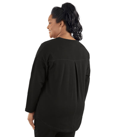 Plus-size women, facing back, wearing Mavie Drop Shoulder V-Neck Tunic in color black.