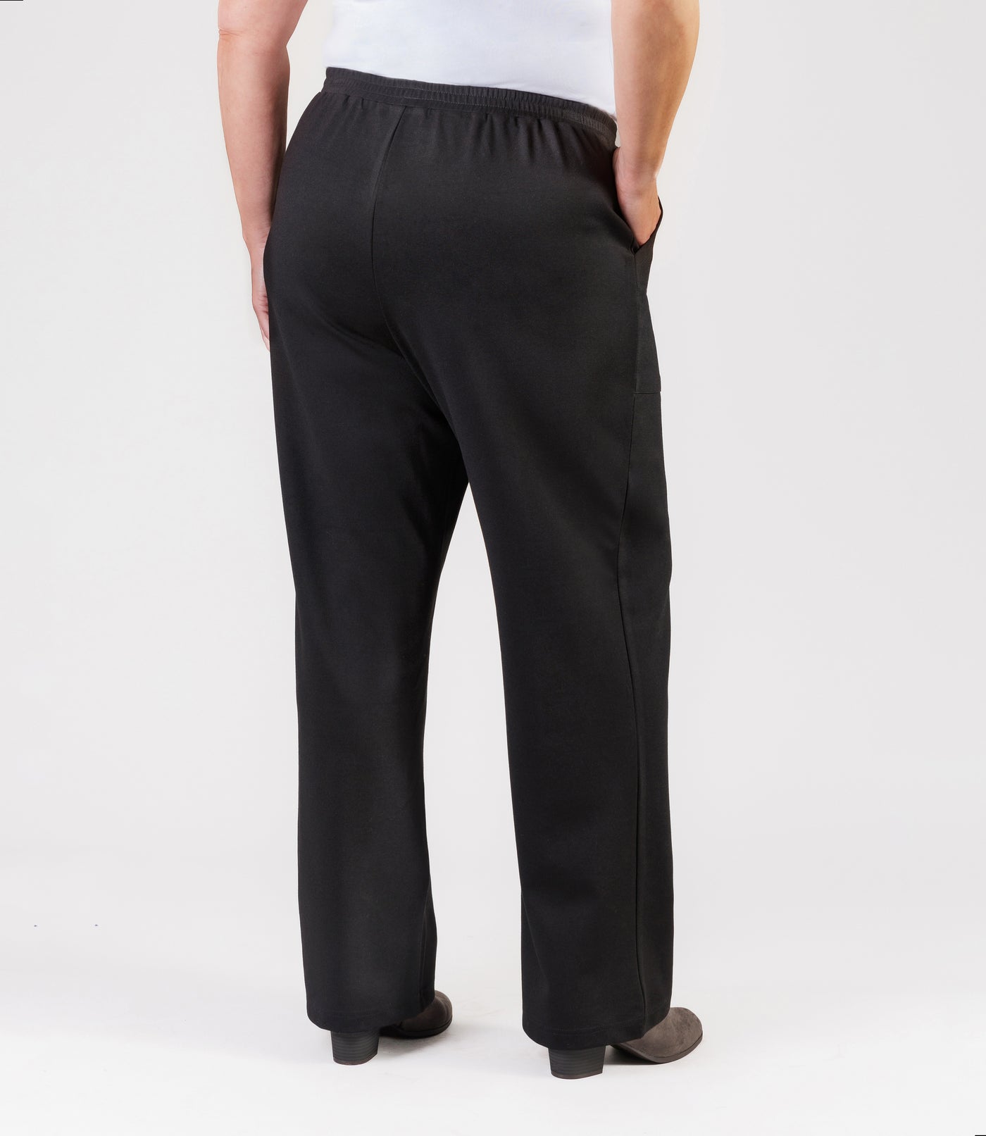 Plus size woman, facing back, wearing JunoActive's Ponte Center Seam Pocketed Pant in color black. 