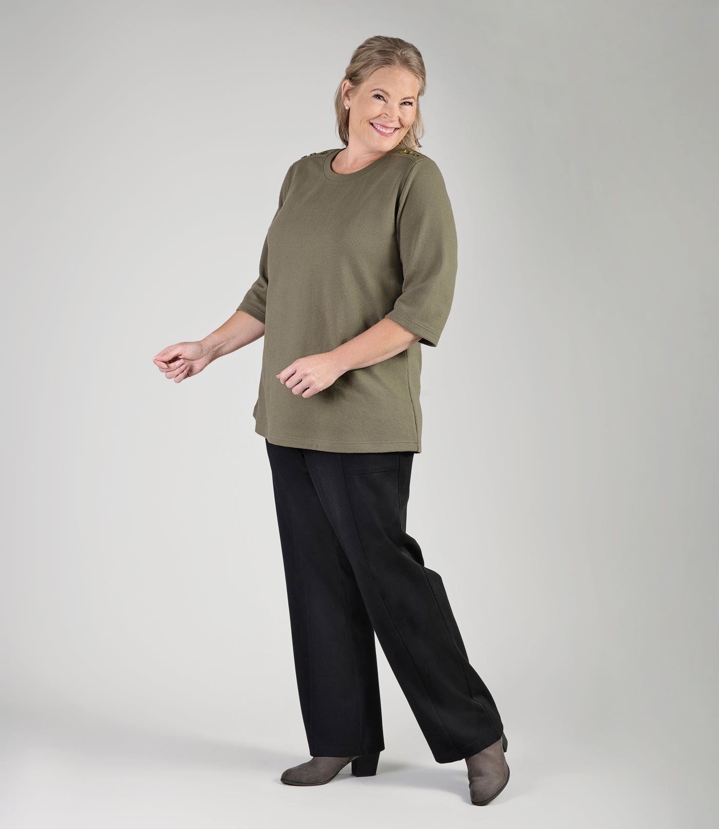 Full body image of plus size woman, facing front with one leg bent, wearing JunoActive's Ponte Center Seam Pocketed plus size pant in color black. 