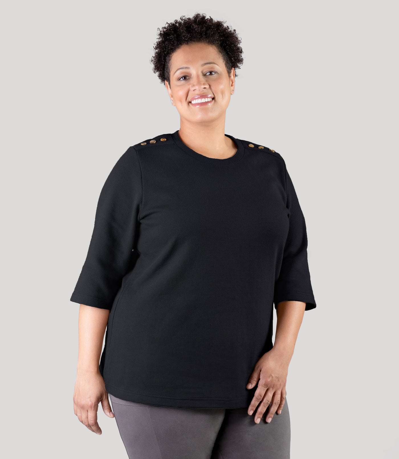 Plus size model, wearing JunoActive's JunoWaffle 3/4 Sleeve Button Top in color black.